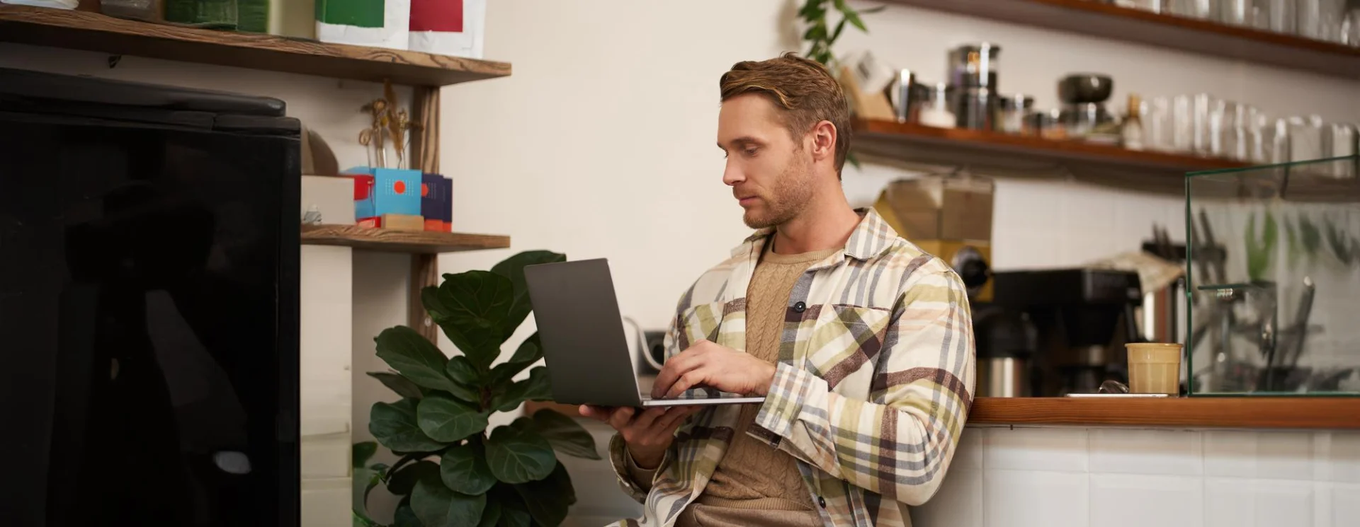 Un homme sur son ordinateur portable, qui veut annuler sa commande de produit numérique